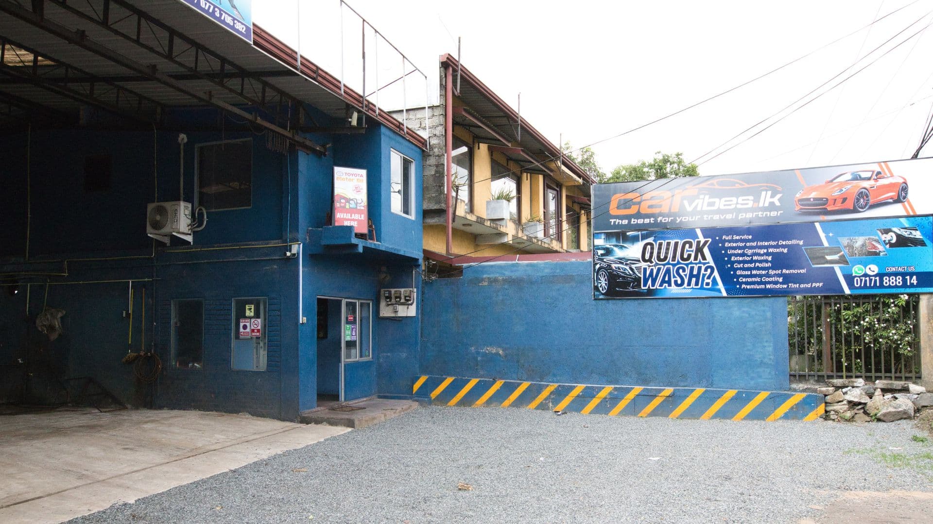 CarVibes facility exterior featuring official branded billboard, service menu, and reception